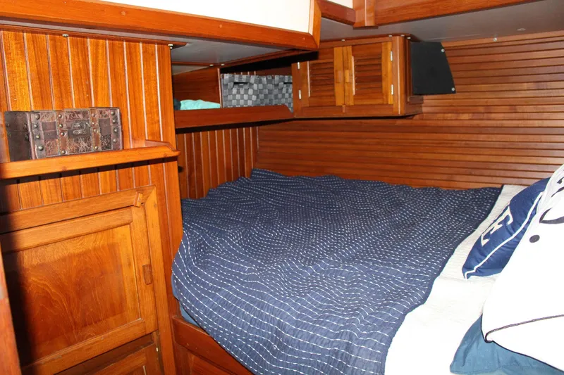 Slide: The Image of Cozy wooden cabin interior of 1990 Slocum 43 sailboat with bed and storage. - 14