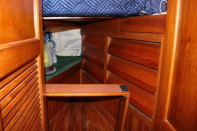 Slide: The Image of Interior of 1990 Slocum 43 sailboat with wooden paneling and storage space. - 21