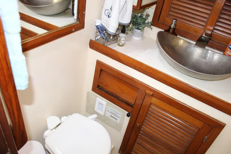 Slide: The Image of 1990 Slocum 43 yacht bathroom with wooden cabinets and modern sink. - 22