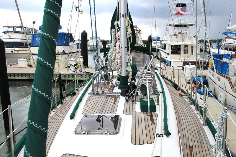 Slide: The Image of Sailboat docked at marina, Slocum 43, 1990 model, with wooden deck and green accents. - 6
