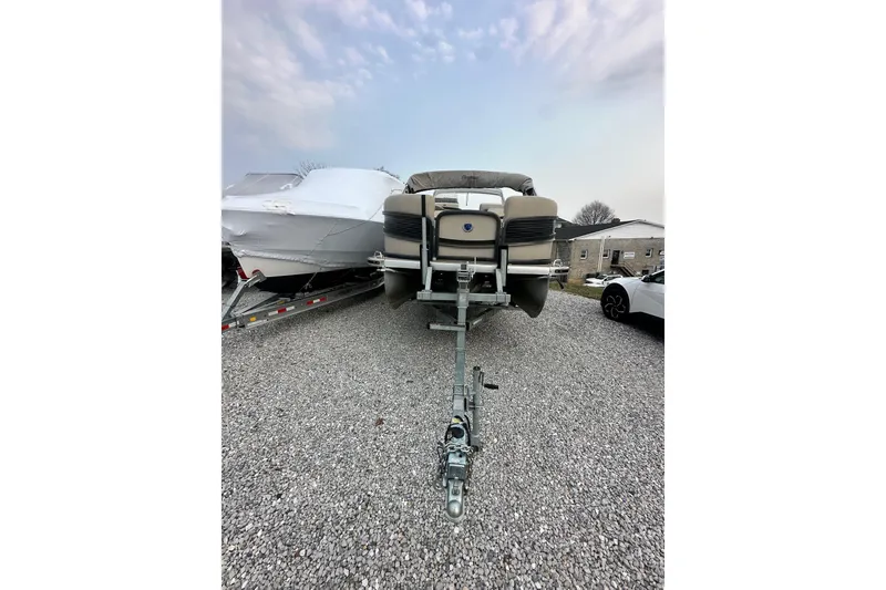 Slide: The Image of 2016 Premier 260 Grand View pontoon boat on trailer, parked on gravel lot. - 1