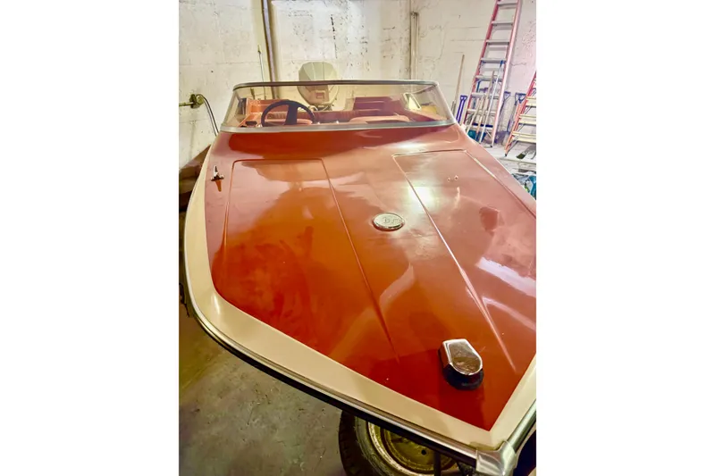 Slide: The Image of 1971 Glastron/Carlson GT 15 boat with red hull in a garage setting. - 16