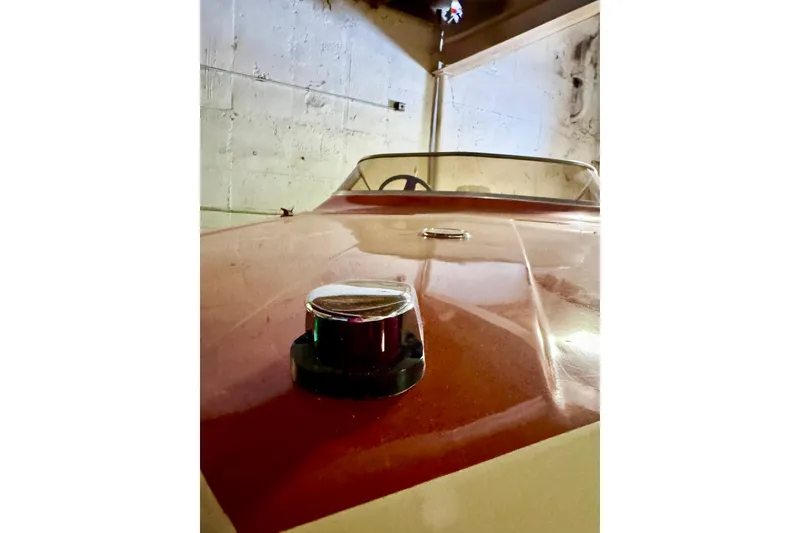 Slide: The Image of 1971 Glastron/Carlson GT 15 boat in a garage, showcasing sleek red design. - 18