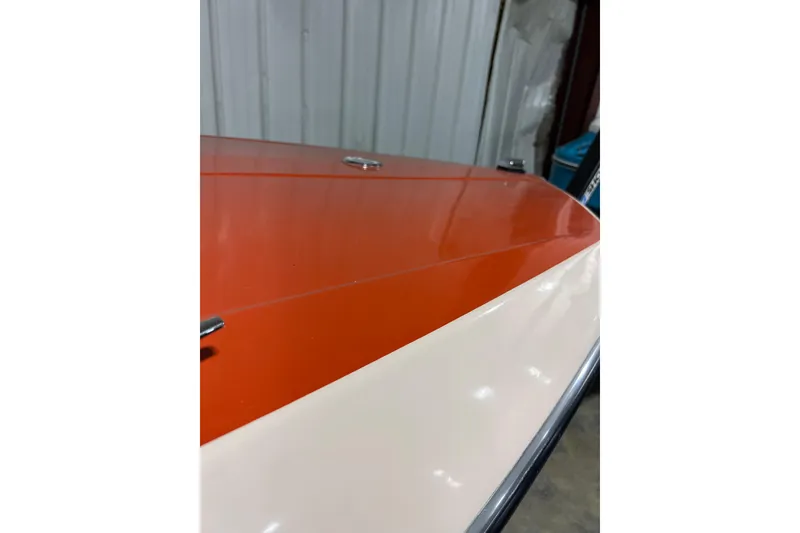 Slide: The Image of 1971 Glastron/Carlson GT 15 boat with orange and white exterior in a garage setting. - 2