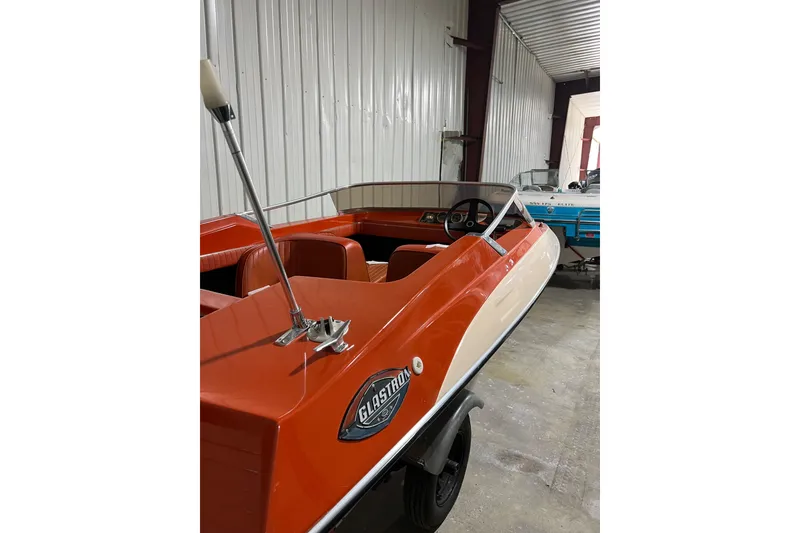 Slide: The Image of 1971 Glastron/Carlson GT 15 boat in storage, featuring orange and white design. - 6