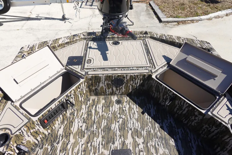 Slide: The Image of 2026 Avid 18 Commander boat interior with open storage compartments and camouflage design. - 11