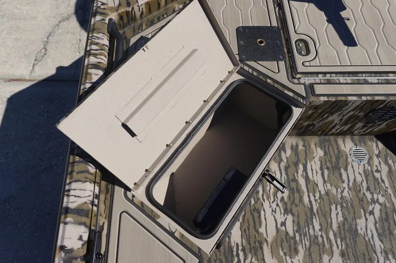 Slide: The Image of Open storage compartment on 2026 Avid 18 Commander boat with camo pattern. - 12