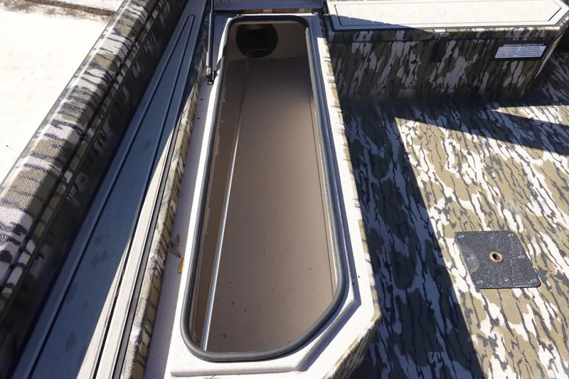 Slide: The Image of 2026 Avid 18 Commander boat interior with camouflage design and open storage compartment. - 18