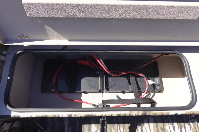 Slide: The Image of Battery compartment of 2026 Avid 18 Commander boat with wiring and straps. - 20
