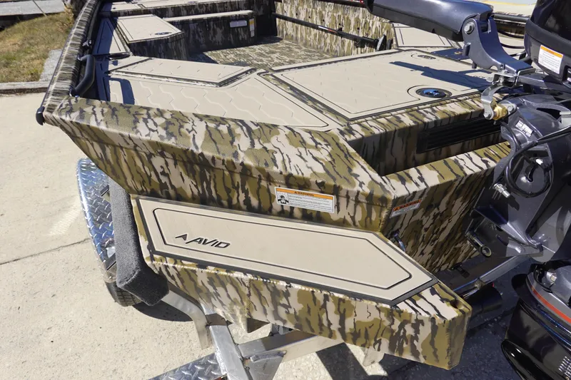 Slide: The Image of 2026 Avid 18 Commander boat with camouflage design and outboard motor on trailer. - 7