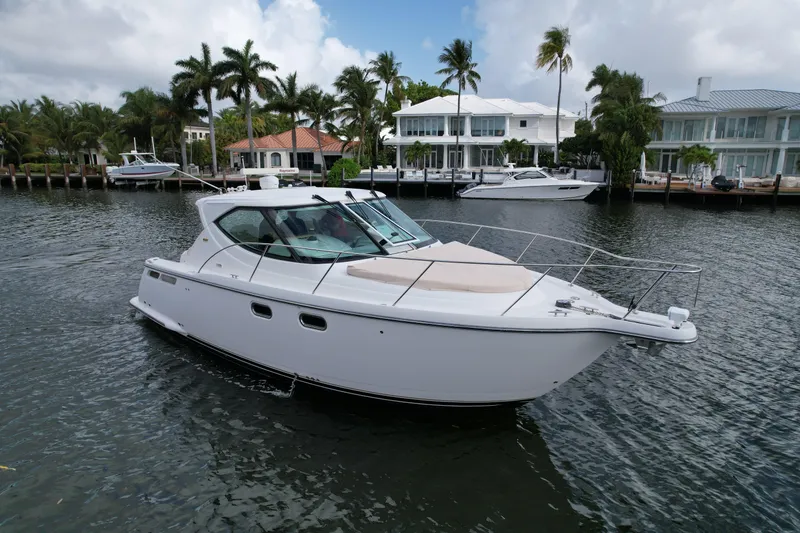 The Image of 2008 Tiara Yachts 3500 Sovran cruising on a scenic waterfront with palm trees. - 0
