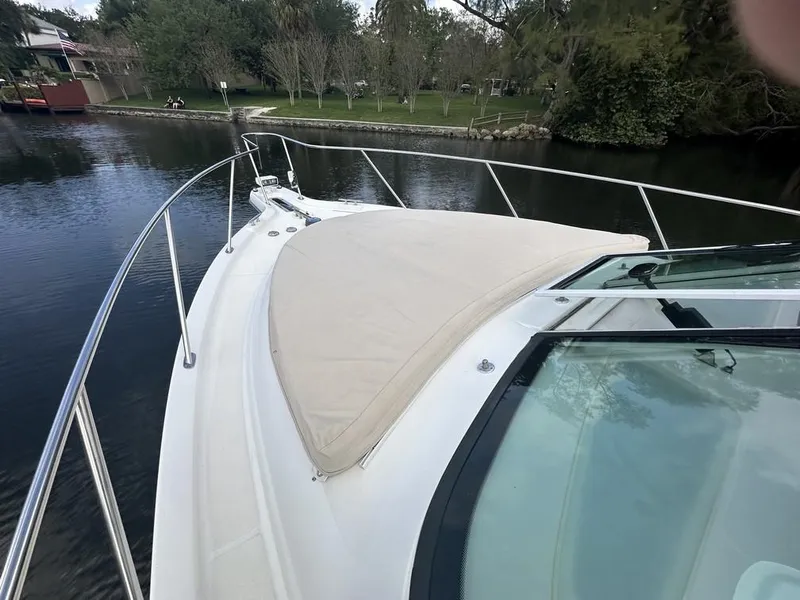 Slide: The Image of 2008 Tiara Yachts 3500 Sovran boat with sunpad, docked by a scenic riverside. - 35