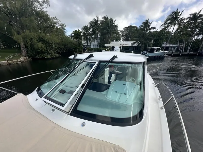 Slide: The Image of 2008 Tiara Yachts 3500 Sovran cruising on a scenic waterway with lush greenery. - 38