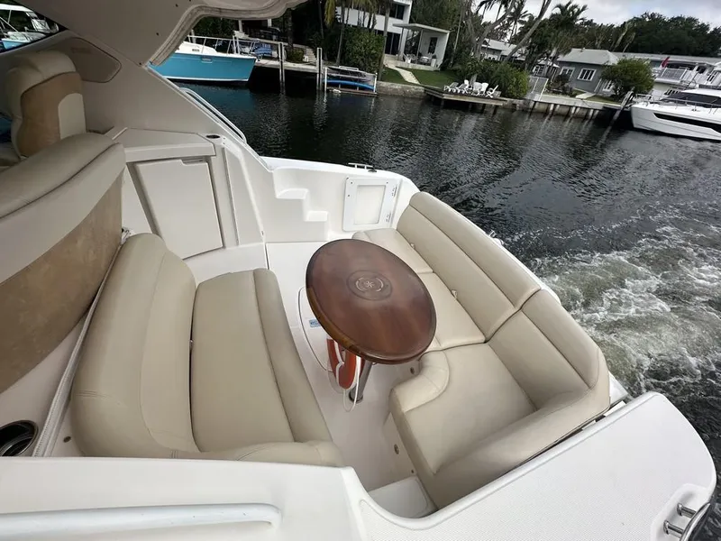 Slide: The Image of 2008 Tiara Yachts 3500 Sovran with beige seating and wooden table on a calm waterway. - 48