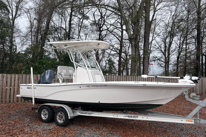 Slide: The Image of 2019 Sea Fox 220 Viper boat on trailer, parked outdoors near trees. - 2