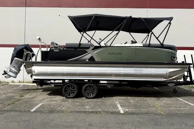 The Image of 2026 Avalon LSZ Quad Lounge Shift pontoon boat on trailer, parked outdoors. - 0