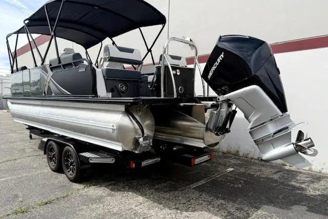 Slide: The Image of 2026 Avalon LSZ Quad Lounge Shift pontoon boat with Mercury outboard motor, parked on trailer. - 17