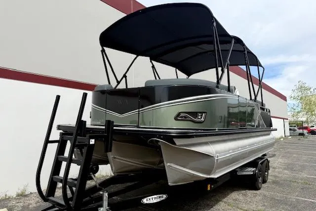 Slide: The Image of 2026 Avalon LSZ Quad Lounge Shift pontoon boat on trailer, parked outdoors. - 19