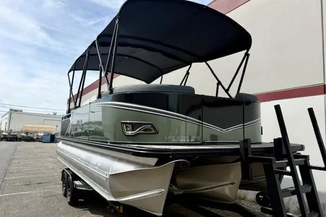 Slide: The Image of 2026 Avalon LSZ Quad Lounge Shift pontoon boat on trailer, outdoor setting. - 2