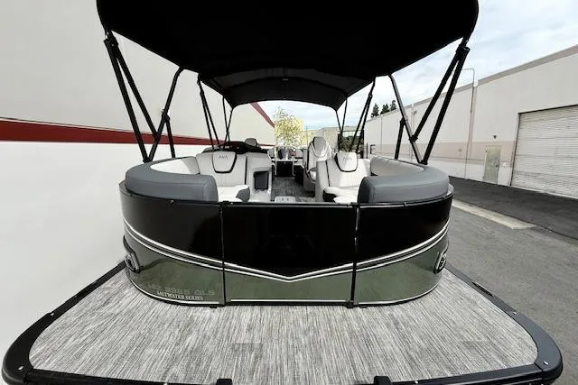 Slide: The Image of 2026 Avalon LSZ Quad Lounge Shift pontoon boat, black and gray, parked outdoors. - 28