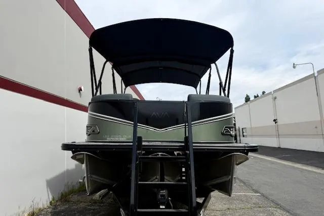 Slide: The Image of 2026 Avalon LSZ Quad Lounge Shift pontoon boat, rear view with canopy, parked outdoors. - 31