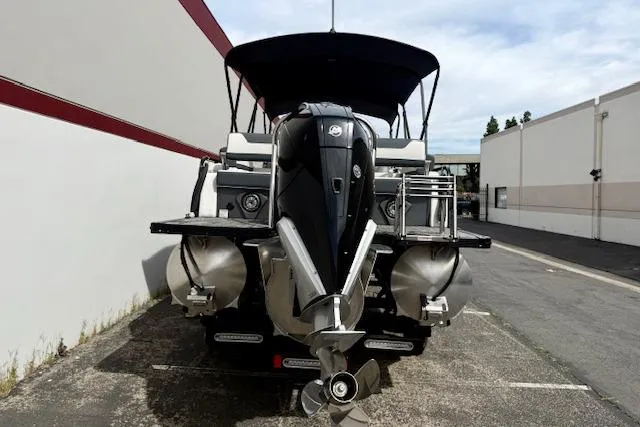 Slide: The Image of 2026 Avalon LSZ Quad Lounge Shift pontoon boat, rear view, parked outdoors. - 32