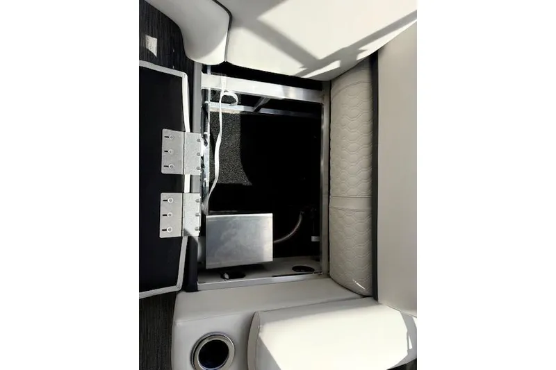 Slide: The Image of 2026 Avalon LSZ Quad Lounge Shift boat storage compartment with open hatch and cup holder. - 6