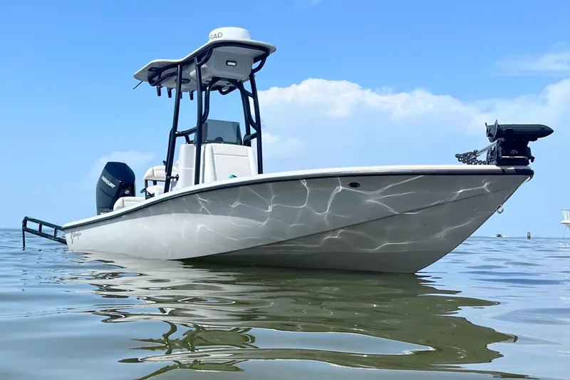 The Image of 2025 Yellowfin 24 Bay CE boat on calm water under clear blue sky. - 1