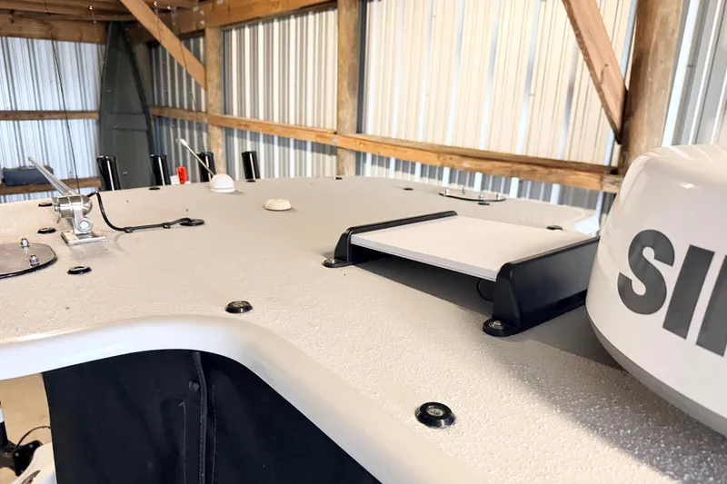 Slide: The Image of 2025 Yellowfin 24 Bay CE boat deck with equipment in a metal shed. - 11