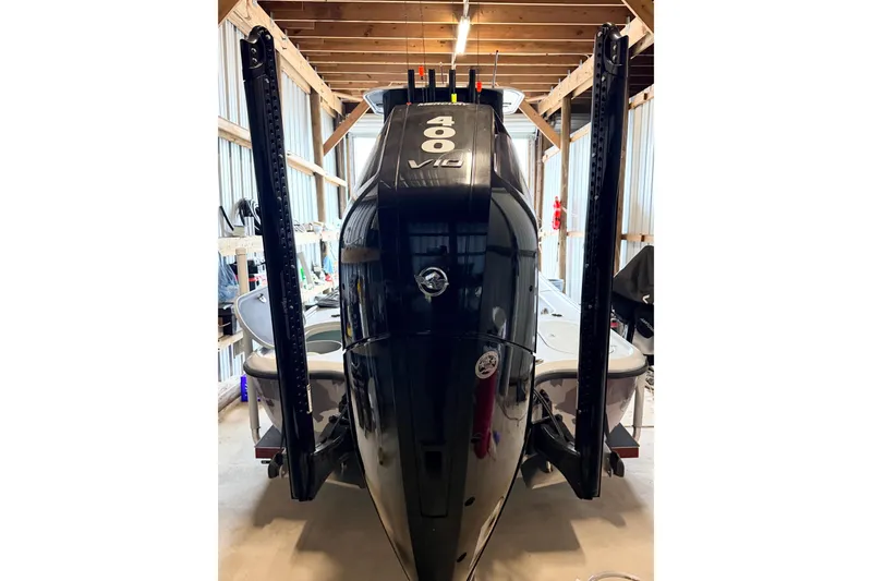 Slide: The Image of 2025 Yellowfin 24 Bay CE boat in a wooden storage shed, rear view. - 6