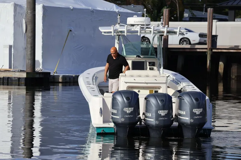 Slide: The Image of Man on 2012 Contender 35 LS boat with Yamaha engines, docked in marina. - 2