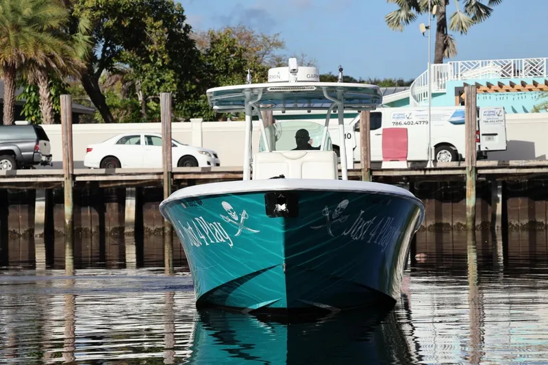 Slide: The Image of 2012 Contender 35 LS boat docked, featuring a teal hull with pirate-themed graphics. - 4