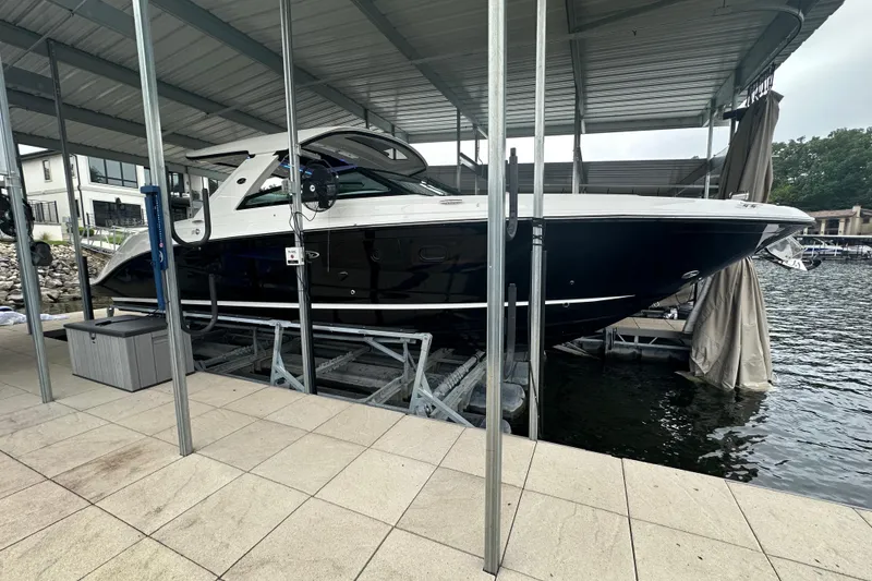 The Image of 2023 Sea Ray SLX 400 boat docked under a covered marina. - 1