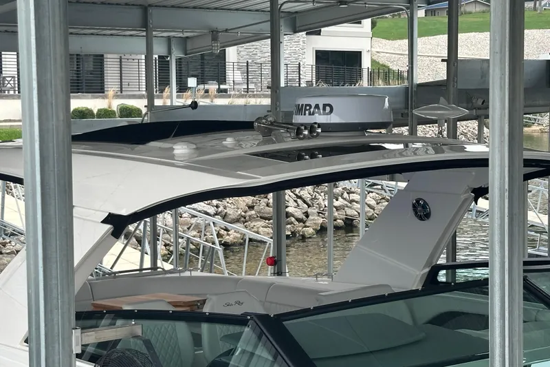 Slide: The Image of 2023 Sea Ray SLX 400 yacht docked under a covered marina. - 10