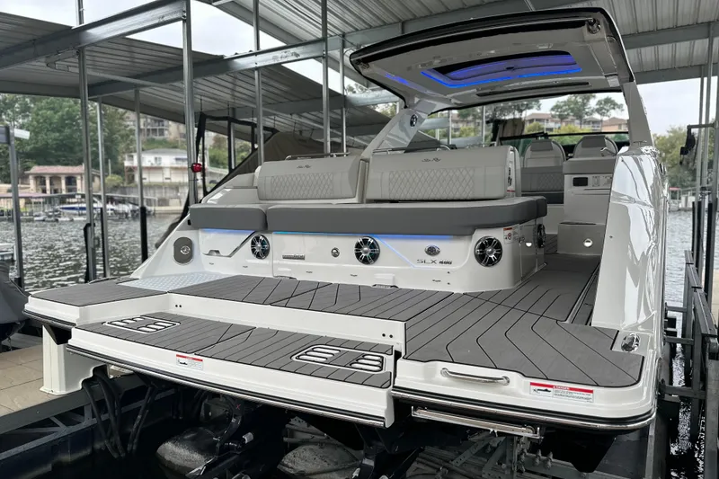 Slide: The Image of 2023 Sea Ray SLX 400 luxury boat docked, showcasing spacious deck and seating area. - 15