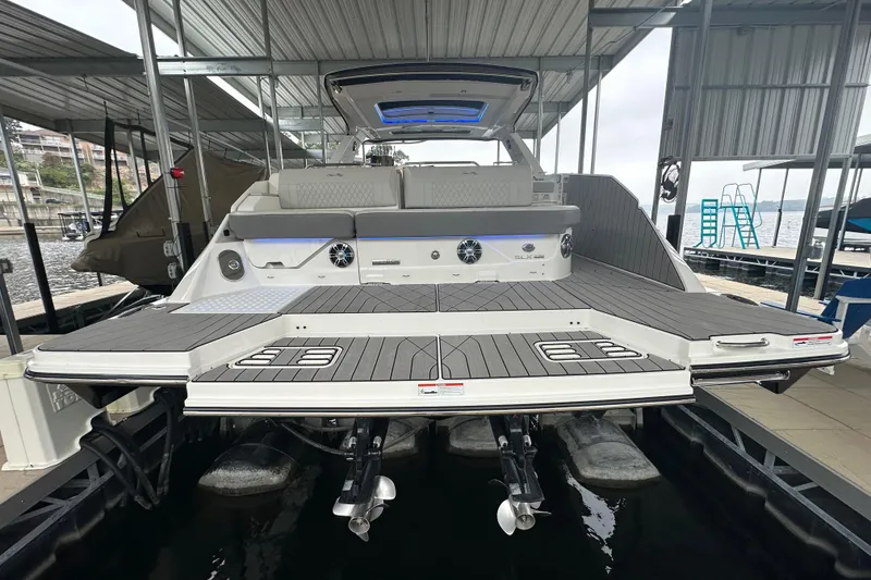 Slide: The Image of 2023 Sea Ray SLX 400 boat docked, showcasing spacious deck and modern design. - 18