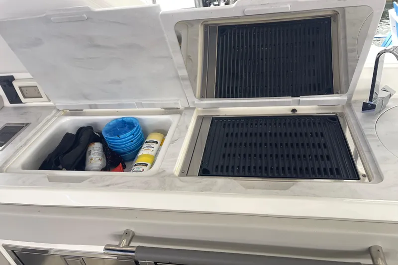 Slide: The Image of Outdoor kitchen on 2023 Sea Ray SLX 400 boat with grill and storage compartments. - 27