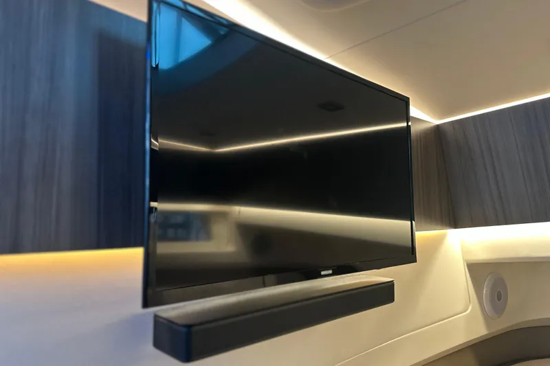 Slide: The Image of Flat-screen TV in 2023 Sea Ray SLX 400 yacht interior with modern wood paneling. - 31