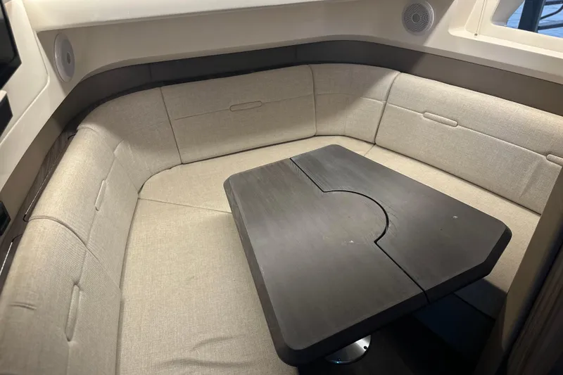 Slide: The Image of 2023 Sea Ray SLX 400 interior with beige seating and a dark wood table. - 38