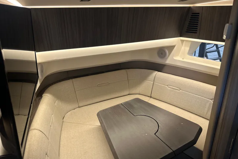 Slide: The Image of 2023 Sea Ray SLX 400 cabin interior with beige seating and wooden table. - 40