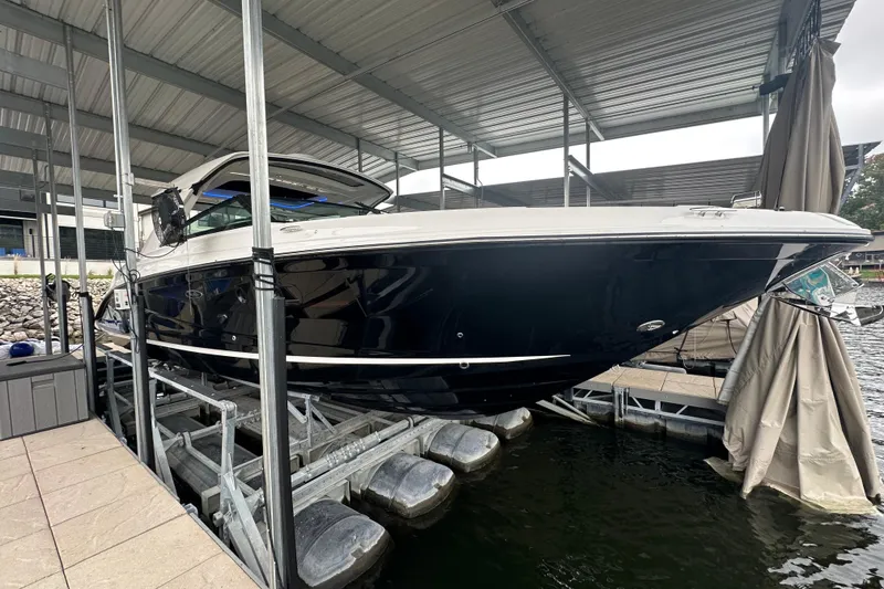 Slide: The Image of 2023 Sea Ray SLX 400 boat docked under a covered marina. - 6