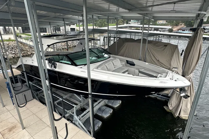 Slide: The Image of 2023 Sea Ray SLX 400 boat docked under a covered marina. - 9