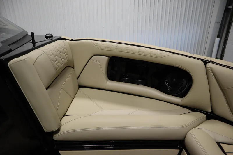 Slide: The Image of 2024 Centurion Ri230 boat with luxurious beige interior in a garage setting. - 13