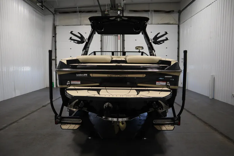 Slide: The Image of 2024 Centurion Ri230 boat in a garage, rear view showcasing sleek design. - 6