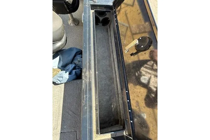 Slide: The Image of 2012 Tracker Targa V-18 WT boat interior storage compartment with cup holders and key. - 18