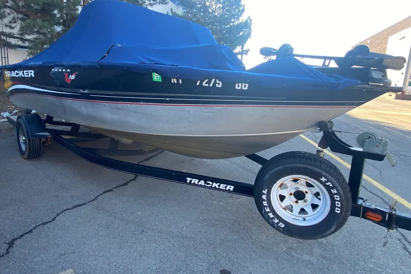 Slide: The Image of 2012 Tracker Targa V-18 WT boat on trailer with blue cover, parked outdoors. - 2
