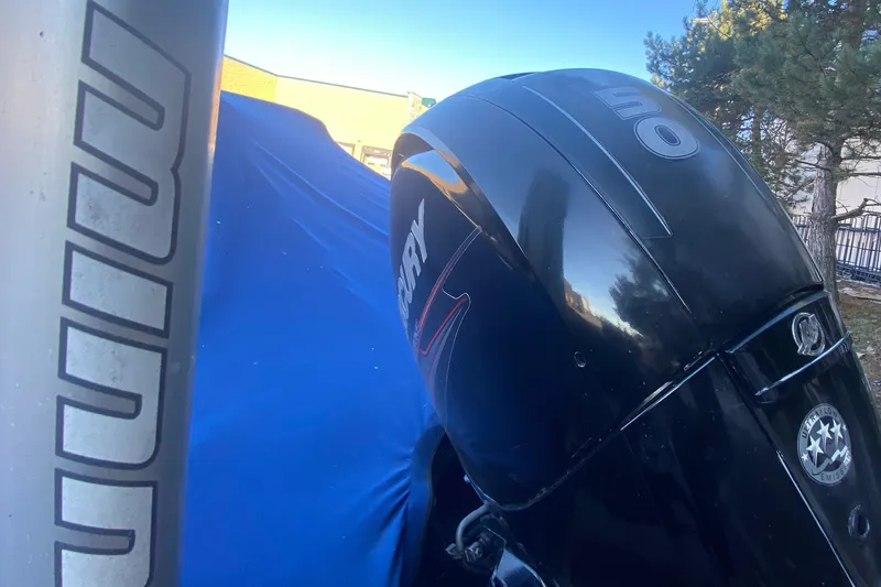 Slide: The Image of 2012 Tracker Targa V-18 WT boat with Mercury outboard motor, covered in blue tarp. - 21