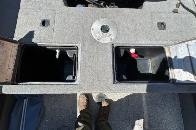 Slide: The Image of 2012 Tracker Targa V-18 WT boat interior with storage compartments and fuel cap. - 7