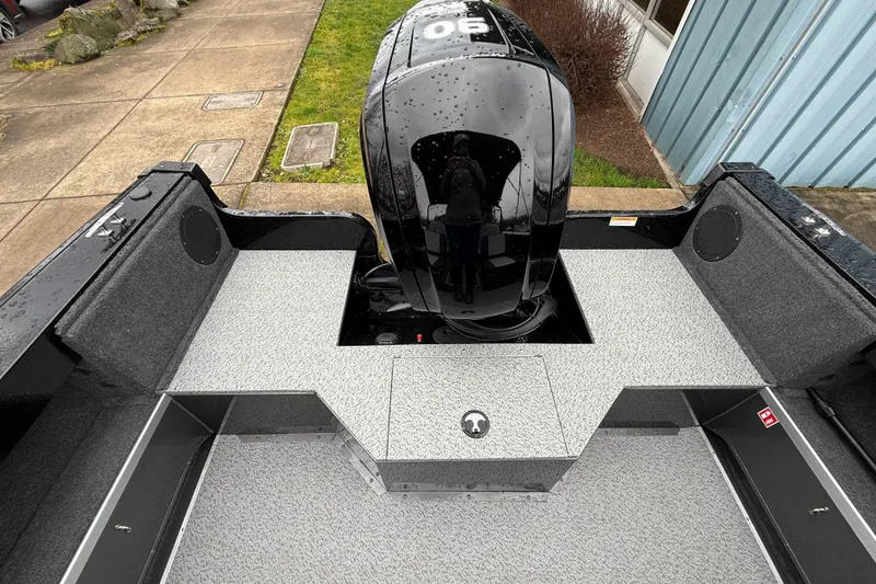 Slide: The Image of 2026 Smoker Craft Osprey 172 boat interior with motor, featuring gray flooring and black accents. - 10
