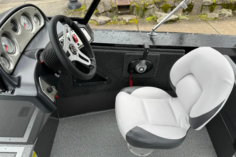 Slide: The Image of 2026 Smoker Craft Osprey 172 boat interior with steering wheel and cushioned seat. - 13